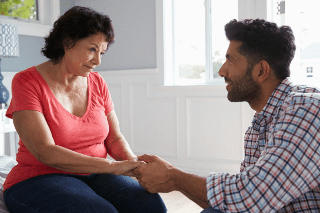 An adult son comforts his aging mother.